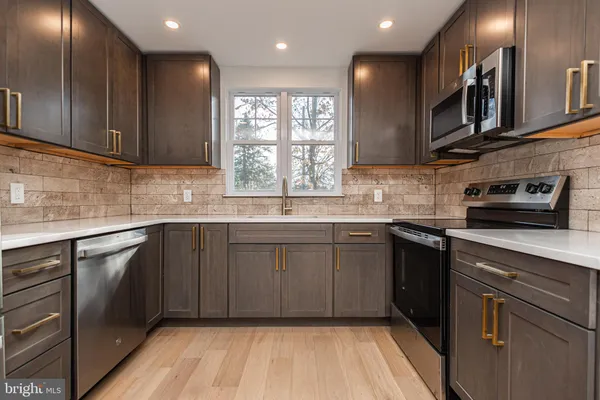 a kitchen with stainless steel appliances granite countertop wooden cabinets a sink and dishwasher