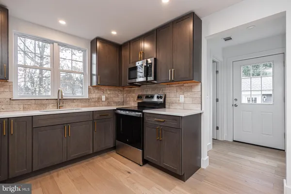 a kitchen with stainless steel appliances granite countertop wooden cabinets a sink and dishwasher
