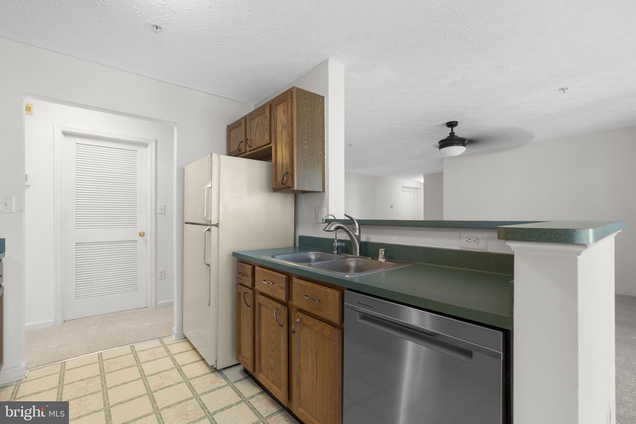 2444 Blue Spring Court, Unit 203 Odenton, MD 21113 - Photo 14 of 36 a kitchen with stainless steel appliances granite countertop a sink and a refrigerator