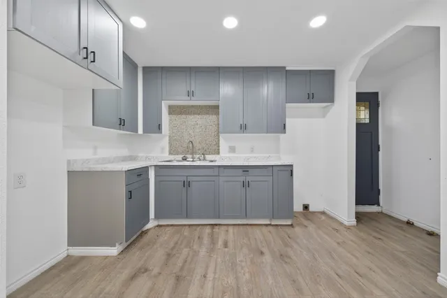 a kitchen with kitchen island white cabinets and refrigerator