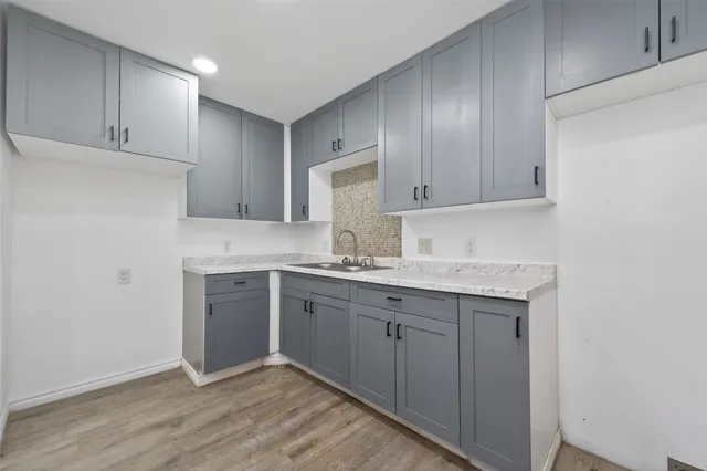 a kitchen with granite countertop cabinets sink and stainless steel appliances