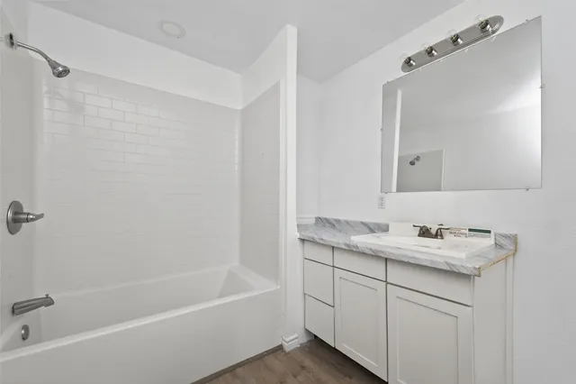 a bathroom with a tub sink and mirror