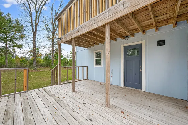 a balcony with wooden floor next to a lake