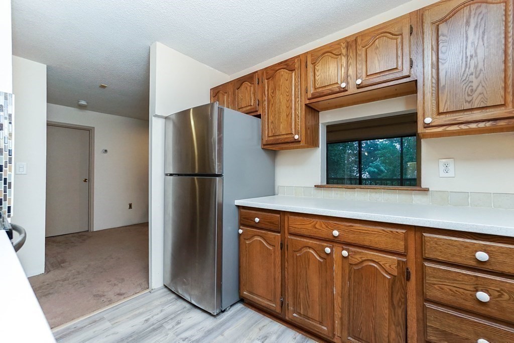 3 Summit Drive, Unit B2 Reading, MA 01867 - Photo 11 of 17 a kitchen with cabinets and stainless steel appliances