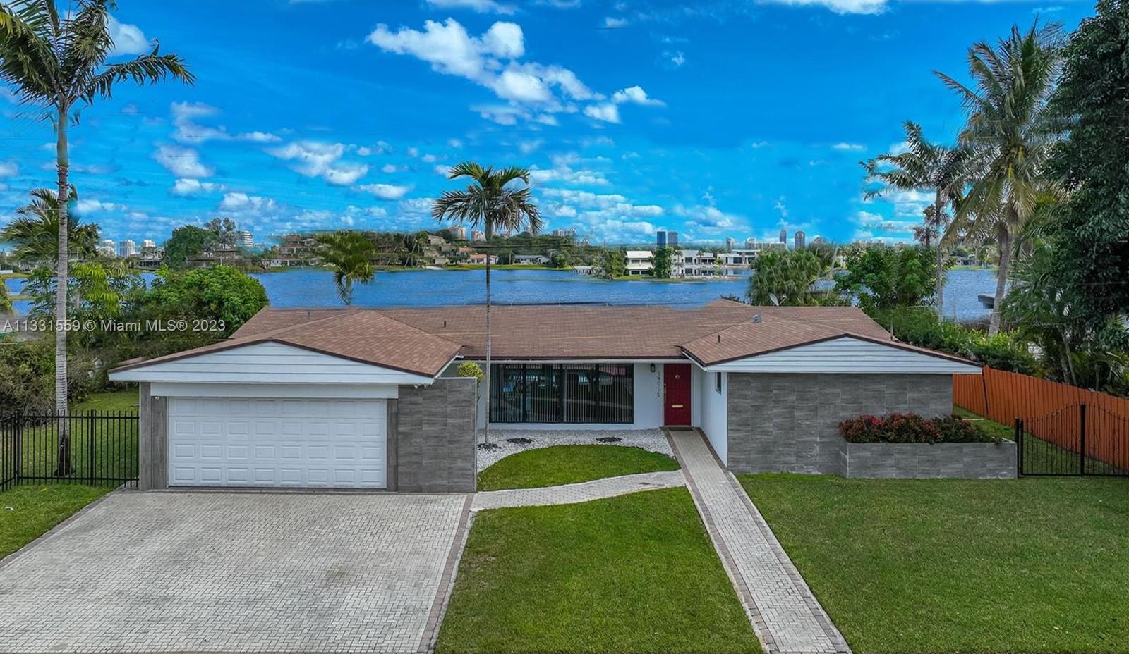 19015 Northeast 18th Avenue Miami, FL 33179 - Photo 1 of 38 a front view of a house with a yard and garage