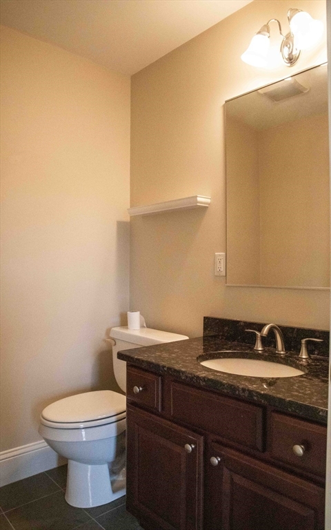 171 North Main Street, Unit 171 Natick, MA 01760 - Photo 10 of 19 a bathroom with a granite countertop toilet and a sink