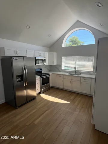 a kitchen with stainless steel appliances granite countertop a refrigerator a sink a stove and island