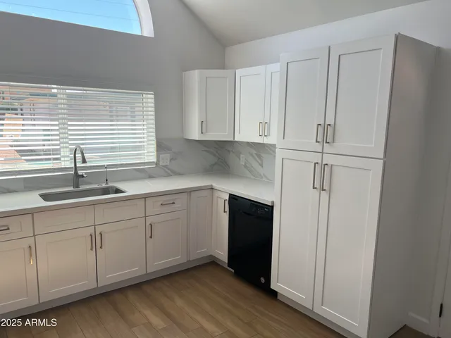 a kitchen with stainless steel appliances granite countertop a sink and a refrigerator