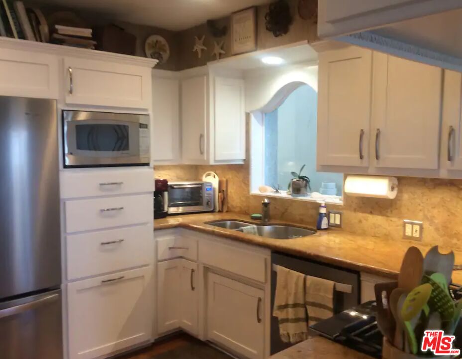 73 A Surfside Avenue Surfside, CA 90743 - Photo 6 of 18 a kitchen with a sink cabinets and appliances
