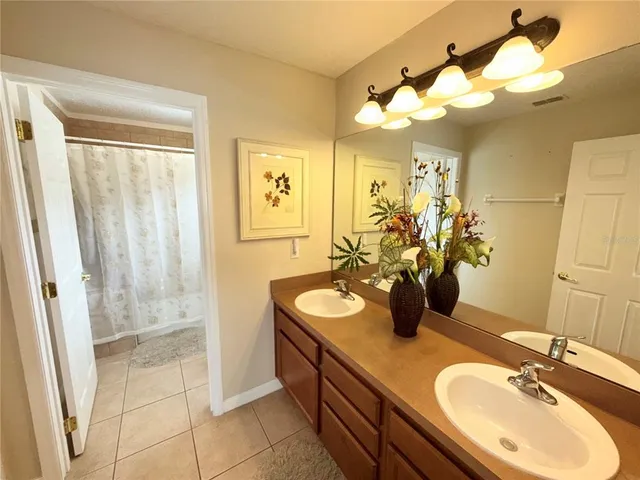 a bathroom with a double vanity sink mirror and shower