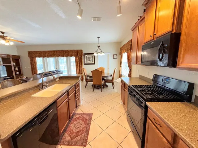 a kitchen with stainless steel appliances granite countertop sink stove and cabinets
