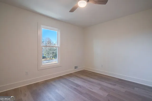 a en suite bathroom with a granite countertop sink mirror and a window