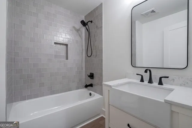 a view of a house with a yard and large tree