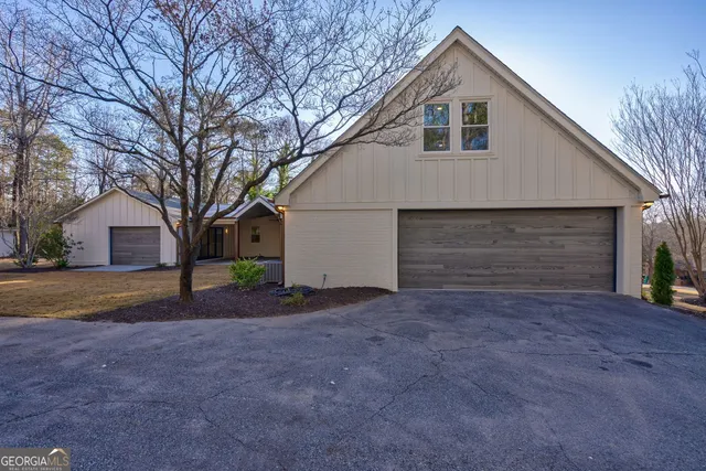 a view of a house with a yard and large tree