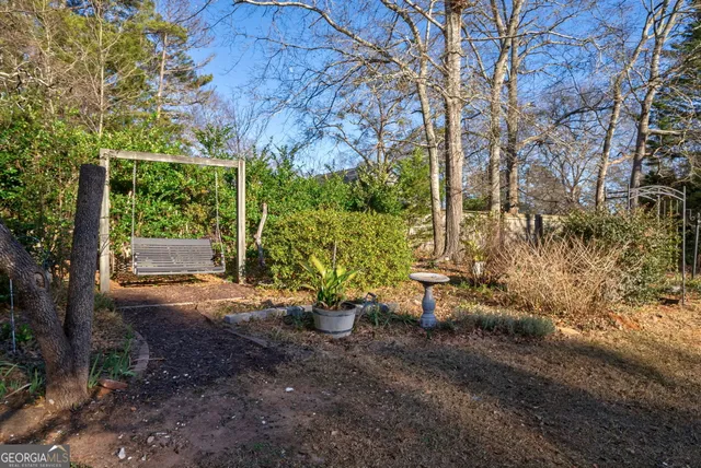 a view of a house with brick walls windows and a tree