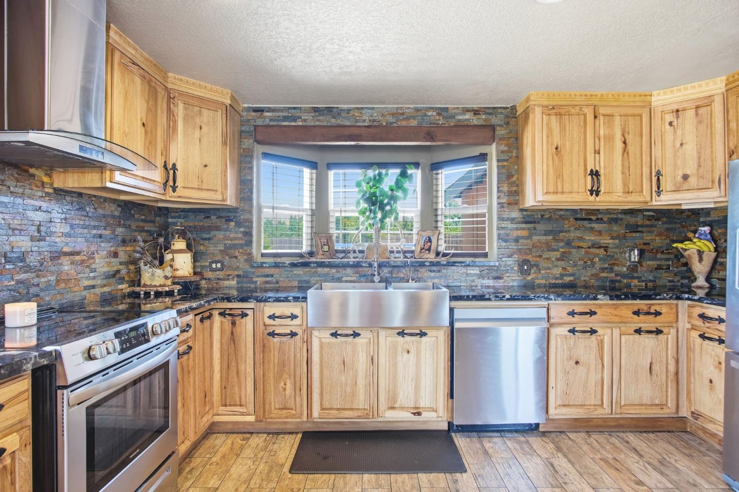 5200 North Gratton Road Denair, CA 95316 - Photo 11 of 40 a kitchen with stainless steel appliances granite countertop a stove a sink and a granite counter tops with wooden floors