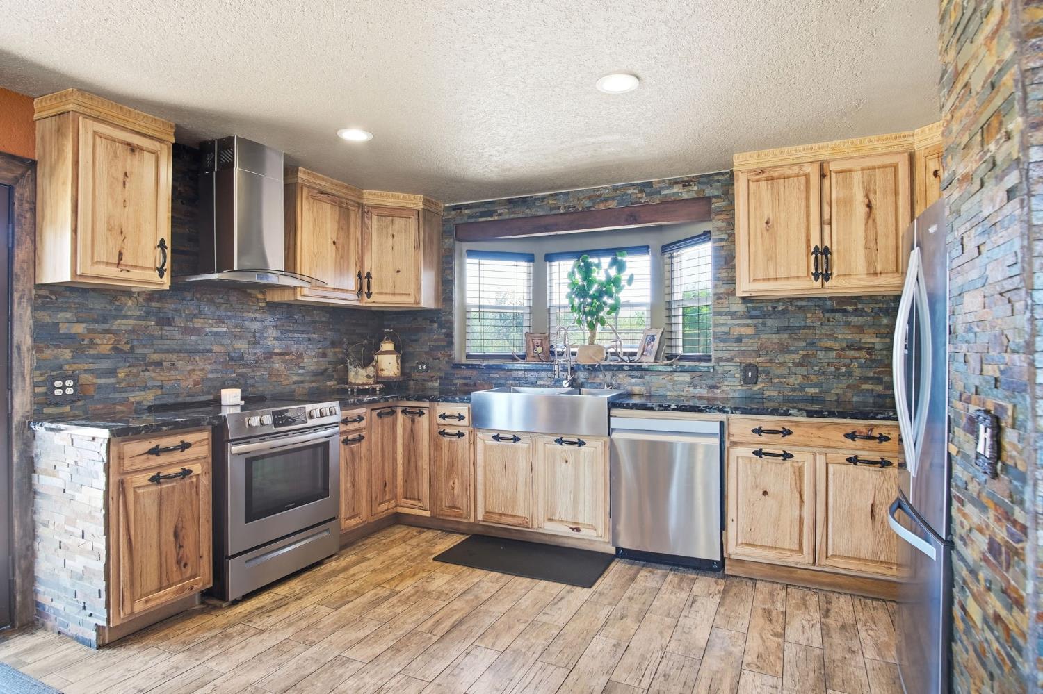 5200 North Gratton Road Denair, CA 95316 - Photo 5 of 40 a kitchen with stainless steel appliances granite countertop a stove and a sink