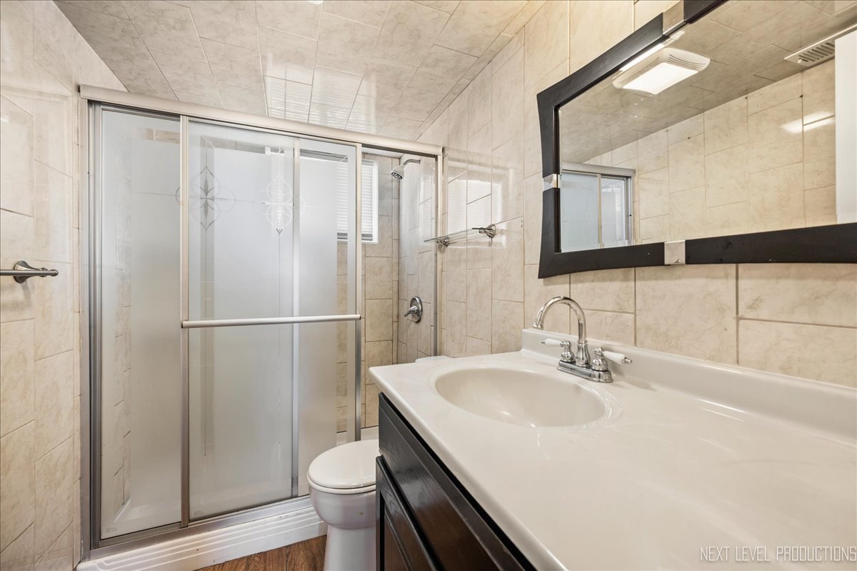 1009 Assell Avenue Aurora, IL 60505 - Photo 14 of 24 a bathroom with a sink toilet and shower