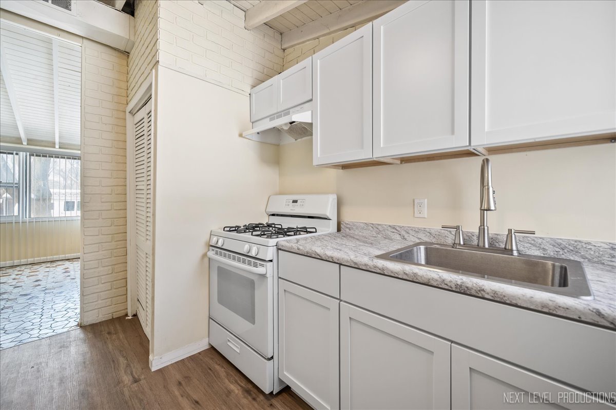 1009 Assell Avenue Aurora, IL 60505 - Photo 16 of 24 a kitchen with granite countertop white cabinets and a stove