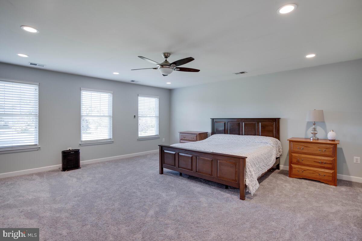 3369 Evans Road Huntingtown, MD 20639 - Photo 36 of 59 a spacious bedroom with a bed and a chandelier