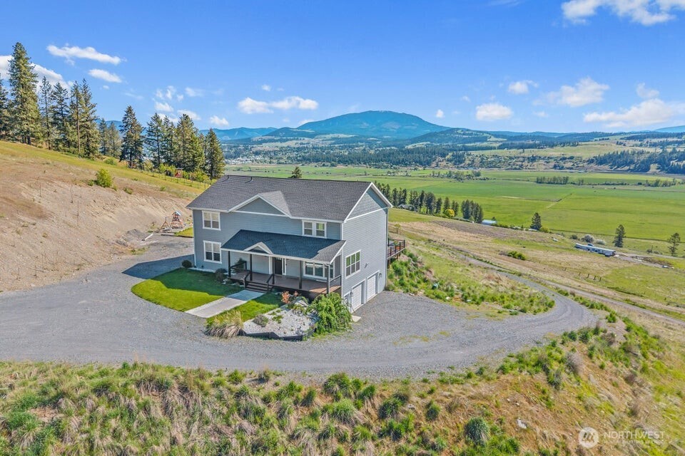 an aerial view of a house with a garden and lake view