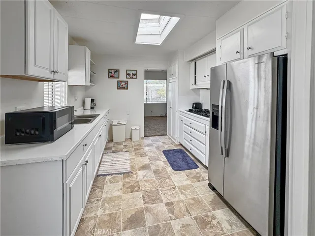 a kitchen with a refrigerator sink and cabinets