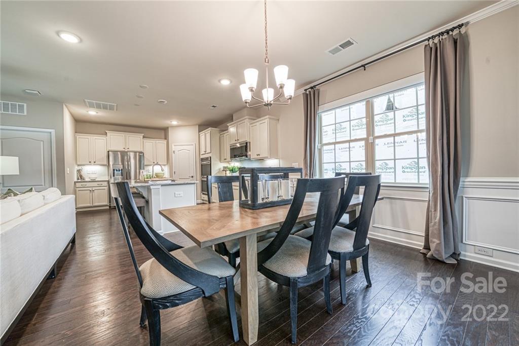 3196 Windhaven Lane, Unit 112 Tega Cay, SC 29708 - Photo 11 of 26 a view of a dining room and livingroom with furniture wooden floor a chandelier