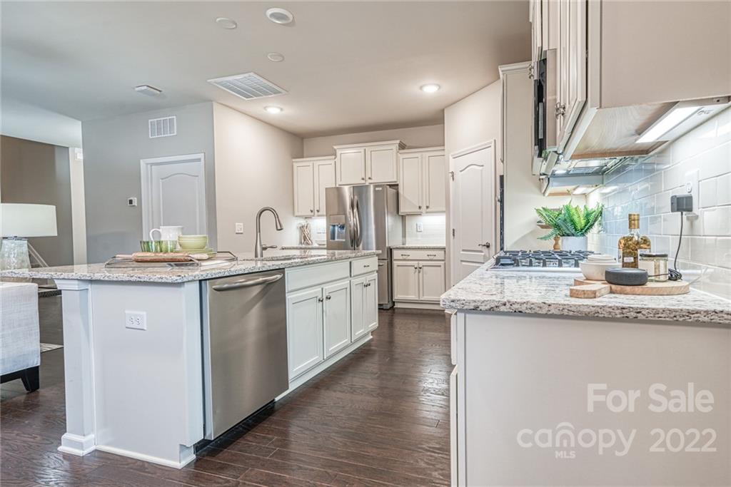 3196 Windhaven Lane, Unit 112 Tega Cay, SC 29708 - Photo 7 of 26 a kitchen with a sink stove cabinets and wooden floor