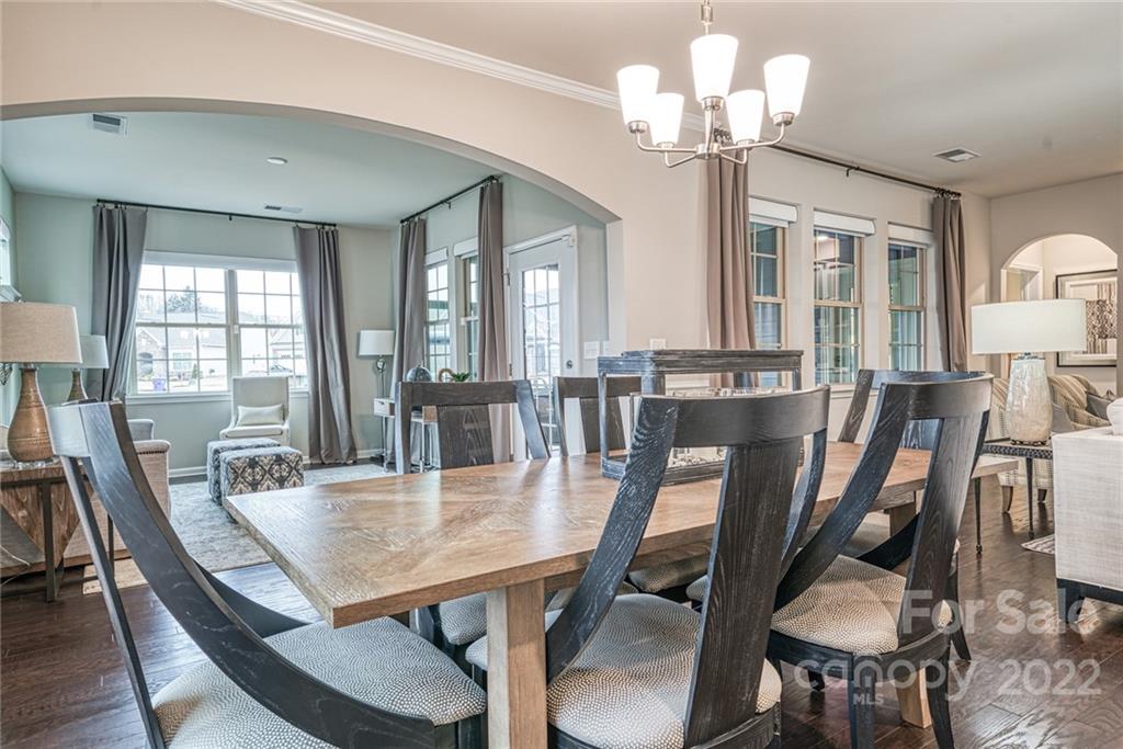 3196 Windhaven Lane, Unit 112 Tega Cay, SC 29708 - Photo 10 of 26 a view of a dining room with furniture a chandelier and wooden floor