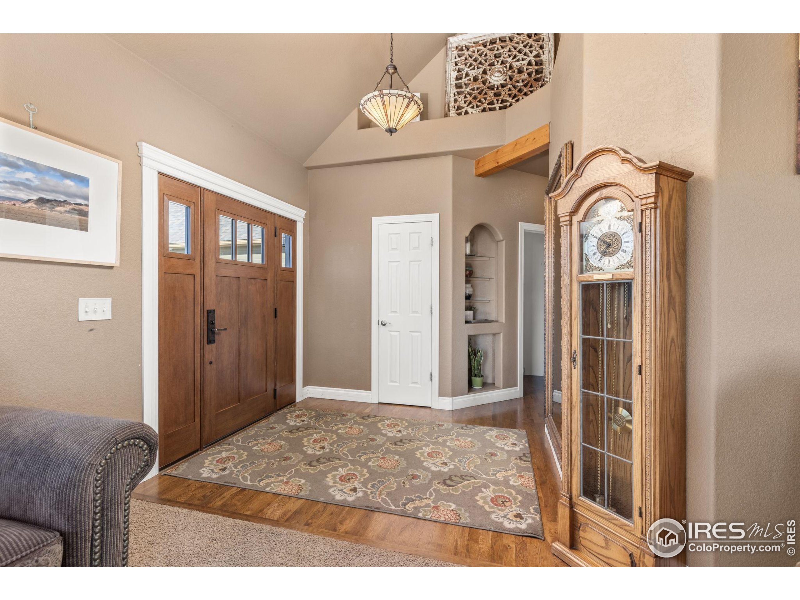 1822 Quarter Lane Berthoud, CO 80513 - Photo 11 of 49 a view of a hallway with entryway wooden floor and a livingroom
