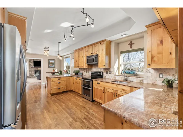 a kitchen with stainless steel appliances kitchen island granite countertop a refrigerator and cabinets