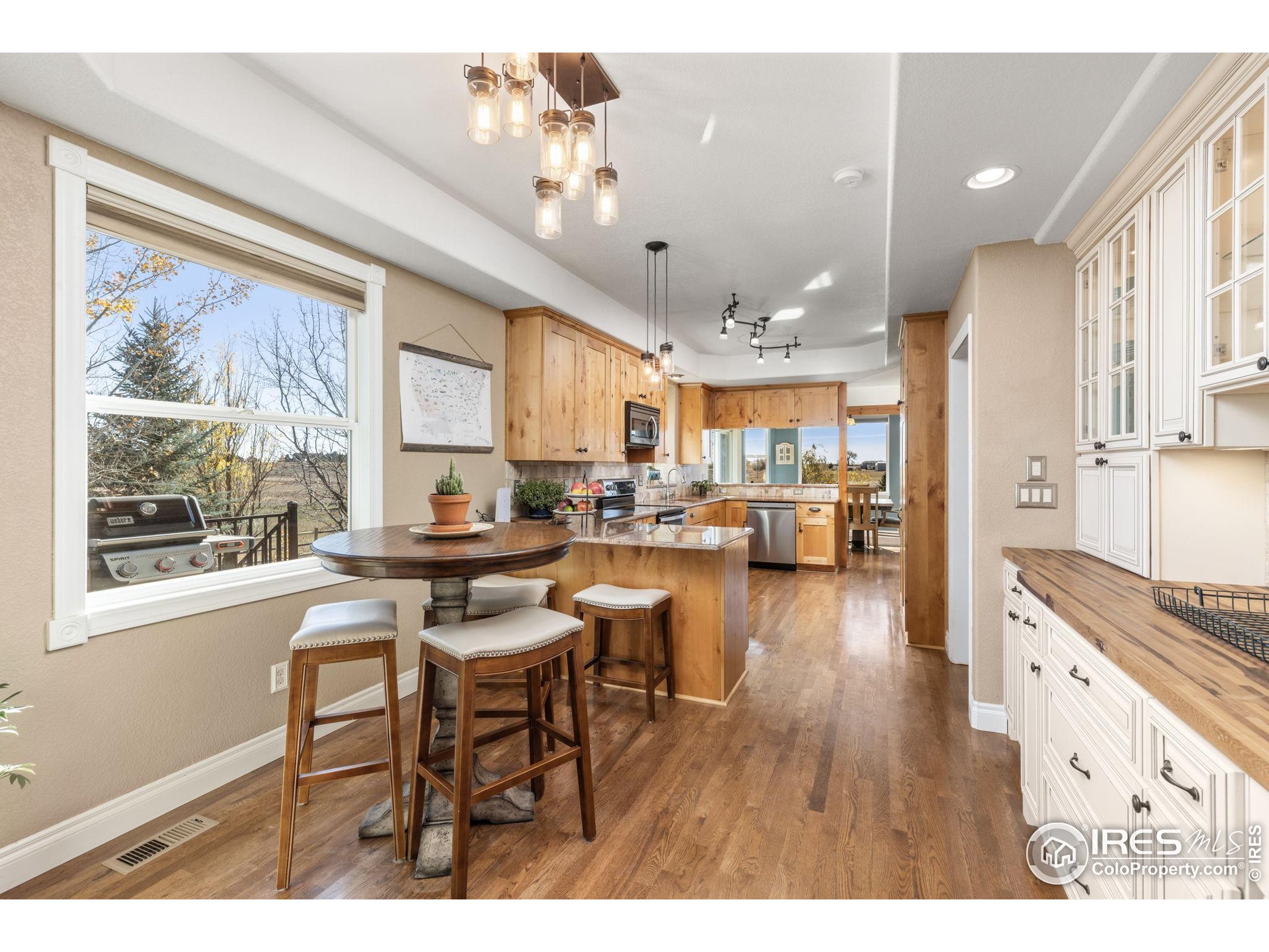 1822 Quarter Lane Berthoud, CO 80513 - Photo 18 of 49 a open dining room with stainless steel appliances kitchen island granite countertop a table chairs and a refrigerator
