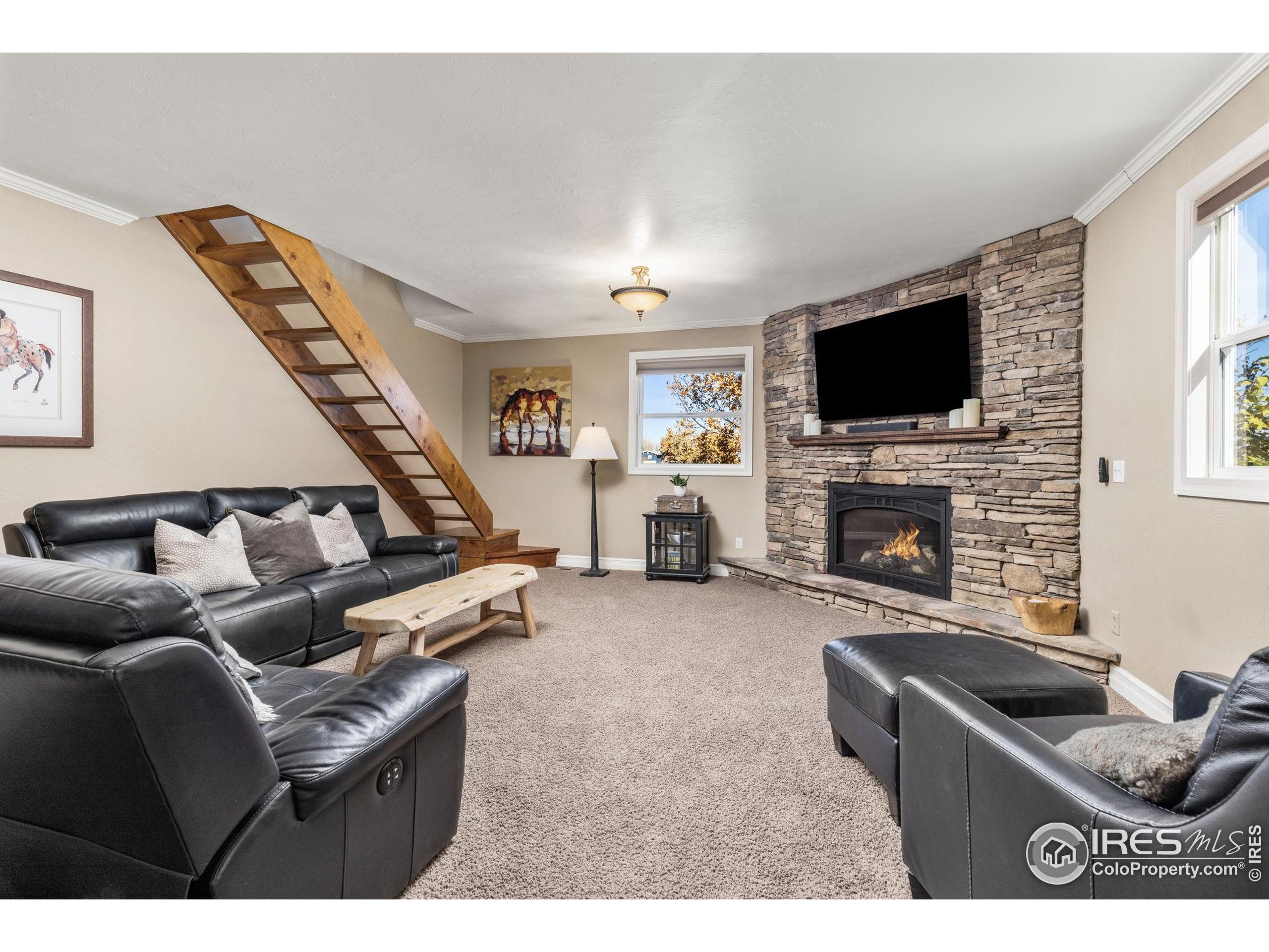 1822 Quarter Lane Berthoud, CO 80513 - Photo 19 of 49 a living room with furniture a flat screen tv and a fireplace