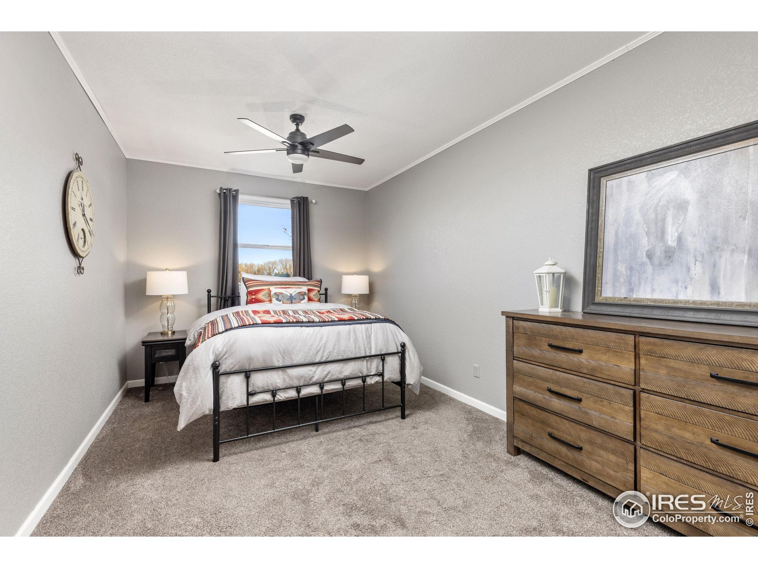 1822 Quarter Lane Berthoud, CO 80513 - Photo 21 of 49 a spacious bedroom with a bed and a chandelier