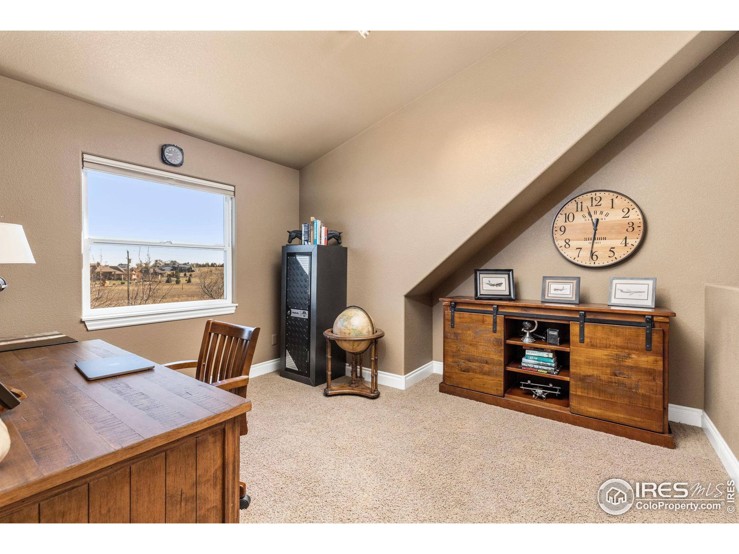 1822 Quarter Lane Berthoud, CO 80513 - Photo 24 of 49 a room with furniture and a clock on the wall