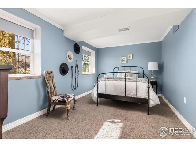 a bedroom with a bed and a lamp on dresser