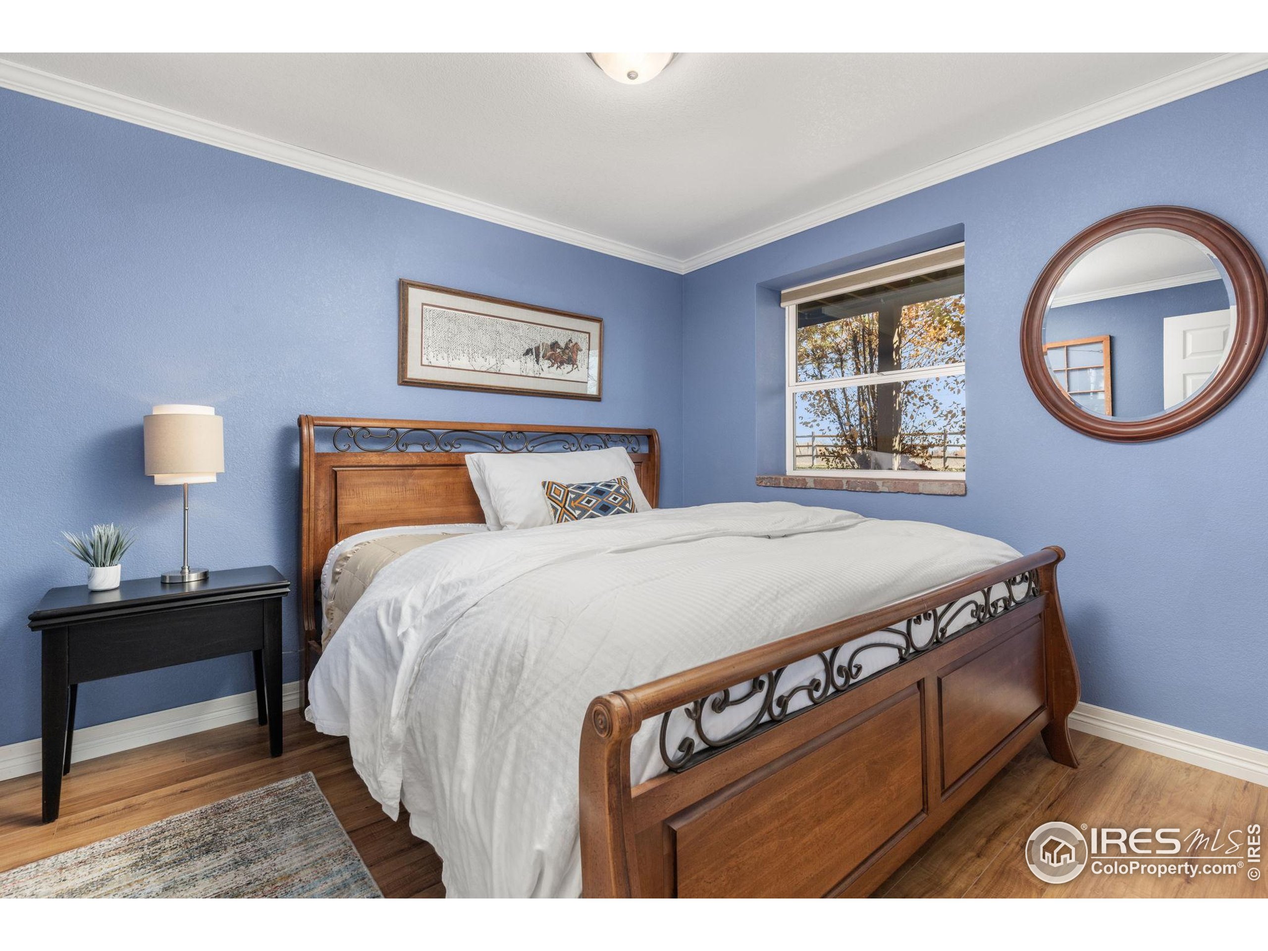 1822 Quarter Lane Berthoud, CO 80513 - Photo 34 of 49 a bedroom with a bed and a lamp on dresser