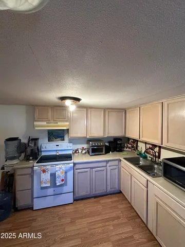 a kitchen with stainless steel appliances granite countertop a stove a sink dishwasher and white cabinets