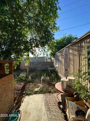 a backyard of a house with table and chairs a barbeque with wooden fence and floor