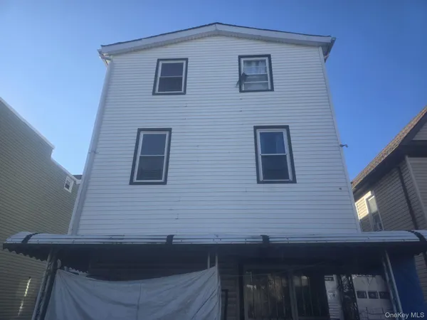 a view of brick house with a small yard
