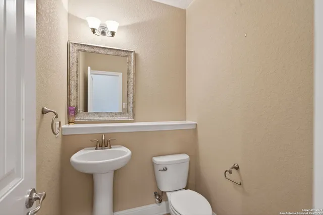 a bathroom with a toilet sink and mirror
