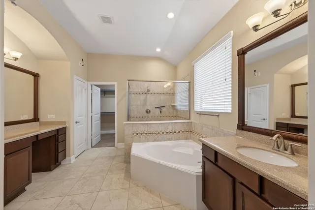 a spacious bathroom with a bathtub sink and mirror