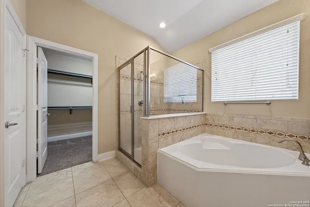 a white bath tub sitting in a en suite bathroom next to a window