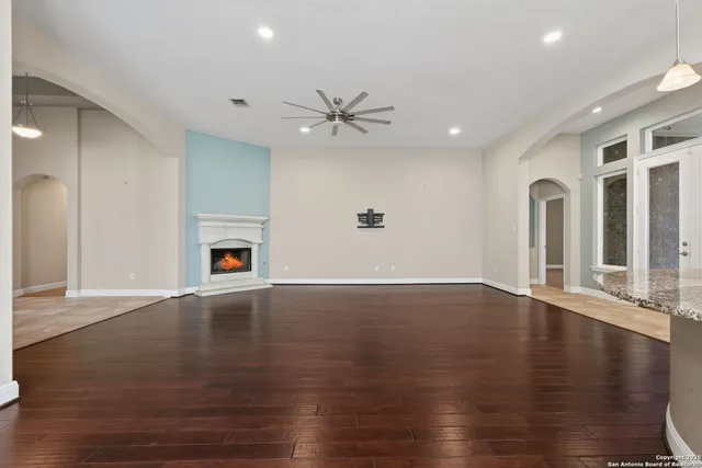 an empty space with wooden floor and a fireplace