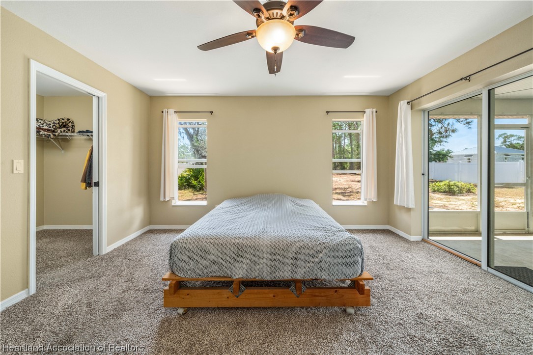 3519 Westminster Road Sebring, FL 33875 - Photo 7 of 31 a spacious bedroom with a bed and a chandelier