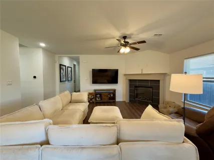 a living room with furniture a fireplace and a flat screen tv