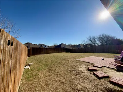 a view of a backyard with a table and chairs under an umbrella