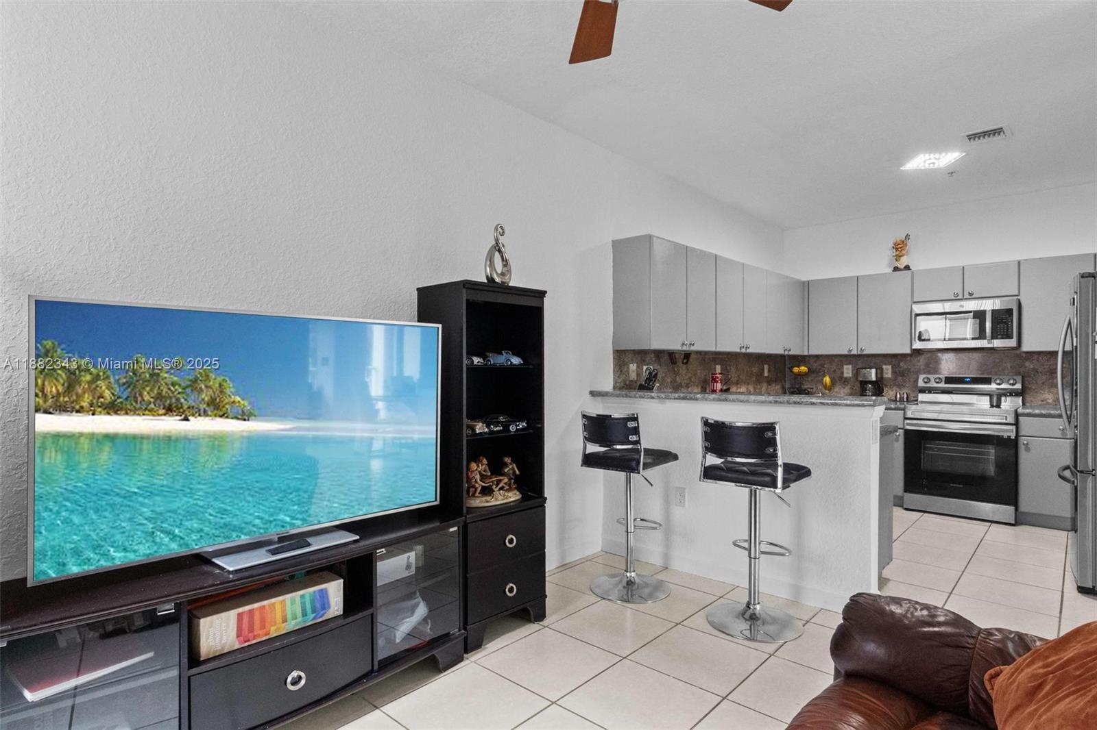 4455 Southwest 160th Avenue, Unit 205 Miramar, FL 33027 - Photo 12 of 44 a kitchen with stainless steel appliances kitchen island granite countertop a refrigerator and stove top oven