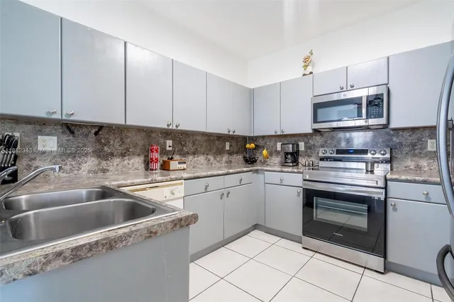 a kitchen with cabinets stainless steel appliances and a sink