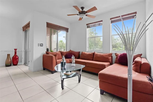 a living room with furniture a fireplace and a large window